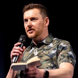 Paul McAvinchey speaking on stage with a microphone